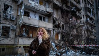 Natali Sevriukova, une habitante de Kiev, se tient devant son immeuble touché par un tir de rocket dans la ville de Kiev, Ukraine le 25 février 2022