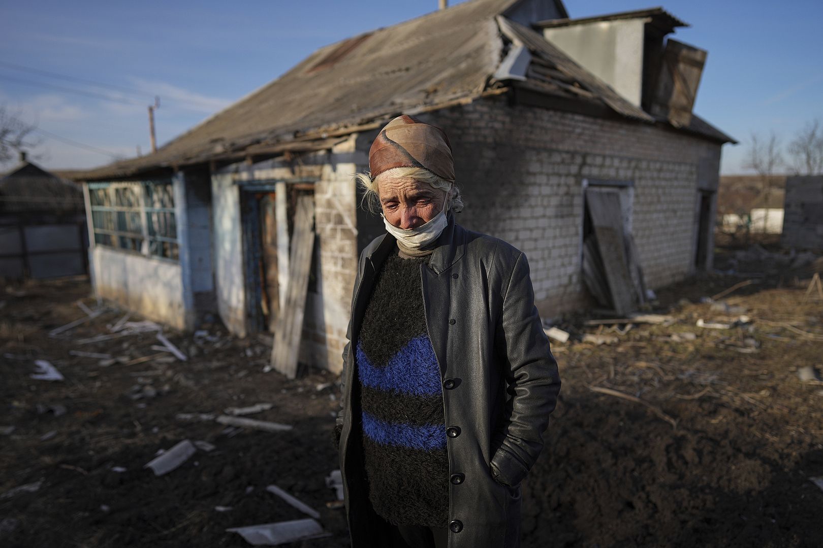 Tetyana Tomenko, a local resident, cries standing in front of her damaged house after shelling by in Novognativka, eastern Ukraine. February 2022