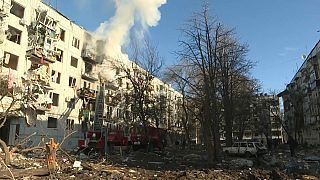 رجال الإطفاء والسكان في موقع قصف لمباني سكنية في تشوغوف، أوكرانيا، الخميس 24 فبراير 2022