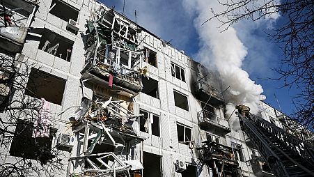 Firefighters work on a fire on a building after bombings on the eastern Ukraine town of Chuguiv on February 24, 2022, as Russian armed forces are trying to invade Ukraine