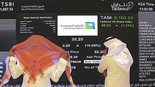 مسؤولو سوق الأسهم السعودية يشاهدون شاشة البورصة التي تعرض شركة النفط السعودية المملوكة للدولة أرامكو، في سوق الأوراق المالية بالرياض في 11 ديسمبر 2019.