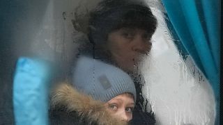 Ukrayna'nın doğusundaki Luhansk bölgesinden ayrılan bir kadın ve çocuk, otobüsün camından dışarı bakarken