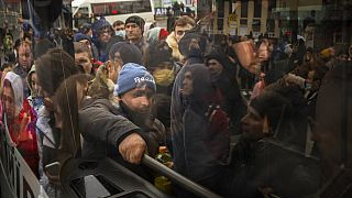 Habitantes de Kiev tratan de subirse a un autobús para salir de la capital ucraniana