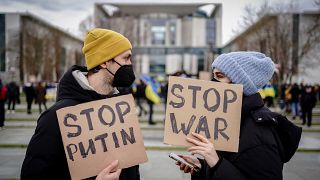 Manifestantes con carteles contra la guerra en Ucrania