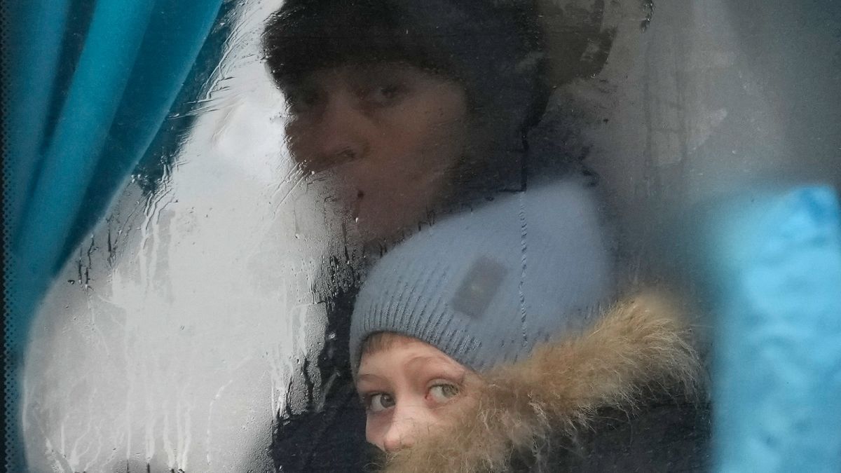 Egy gyermek és egy nő menekül buszon a luhanszki térségből, 2022. február 24-én