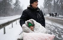 An elderly woman is coated in snow as she sits in a wheelchair after being evacuated from Irpin, on the outskirts of Kyiv, Ukraine. March 8, 2022