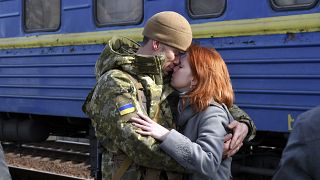 Un couple s'enlace avant qu'elle ne monte dans le train en gare de Kramatorsk en direction de l'ouest de l'Ukraine, dimanche 27 février 2022