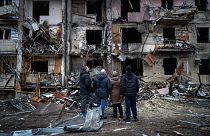 Menschen betrachten die Schäden nach einem Raketenangriff auf die Stadt Kiew,