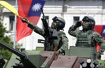 FILE - Taiwanese soldiers salute during National Day celebrations in front of the Presidential Building in Taipei, Taiwan on Oct. 10, 2021.
