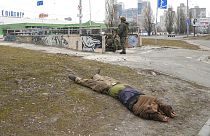 Ukrán katona figyeli a környéket Kijevben - mellette egy lelőtt katona holtteste