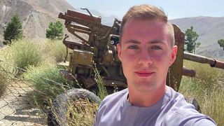 Miles Routledge takes a selfie with military equipment 
