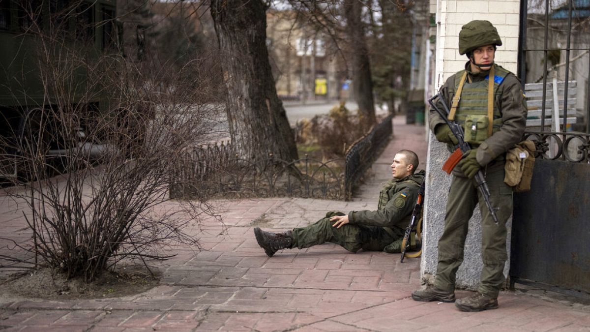 Un soldado ucraniano sentado, herido por el fuego cruzado en la ciudad de Kyiv, Ucrania