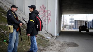 متطوعان أوكرانيان يحملان السلاح في كييف