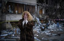 Natali Sevriukova reacts as she stands next to her house following a rocket attack in the city of Kyiv, Ukraine, Feb. 25, 2022.