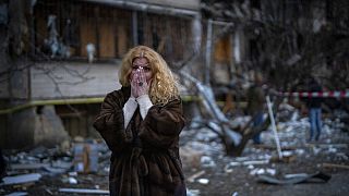Natali Sevriukova reacts as she stands next to her house following a rocket attack in the city of Kyiv, Ukraine, Feb. 25, 2022.