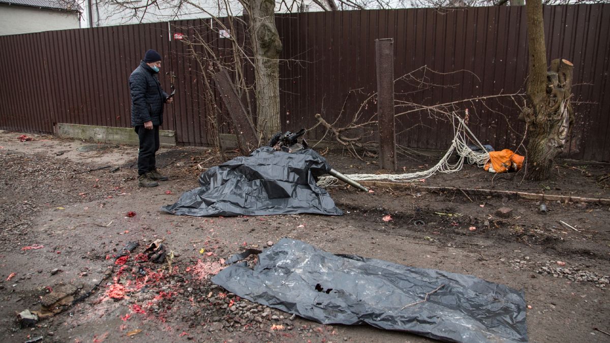 شظايا جثث الضحايا المغطاة بالبلاستيك الأسود على جانب طائرة سقطت في كييف بأوكرانيا يوم الجمعة 25 فبراير 2022.