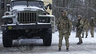 Ukrainische Soldaten neben einem russischen Fahrzeug