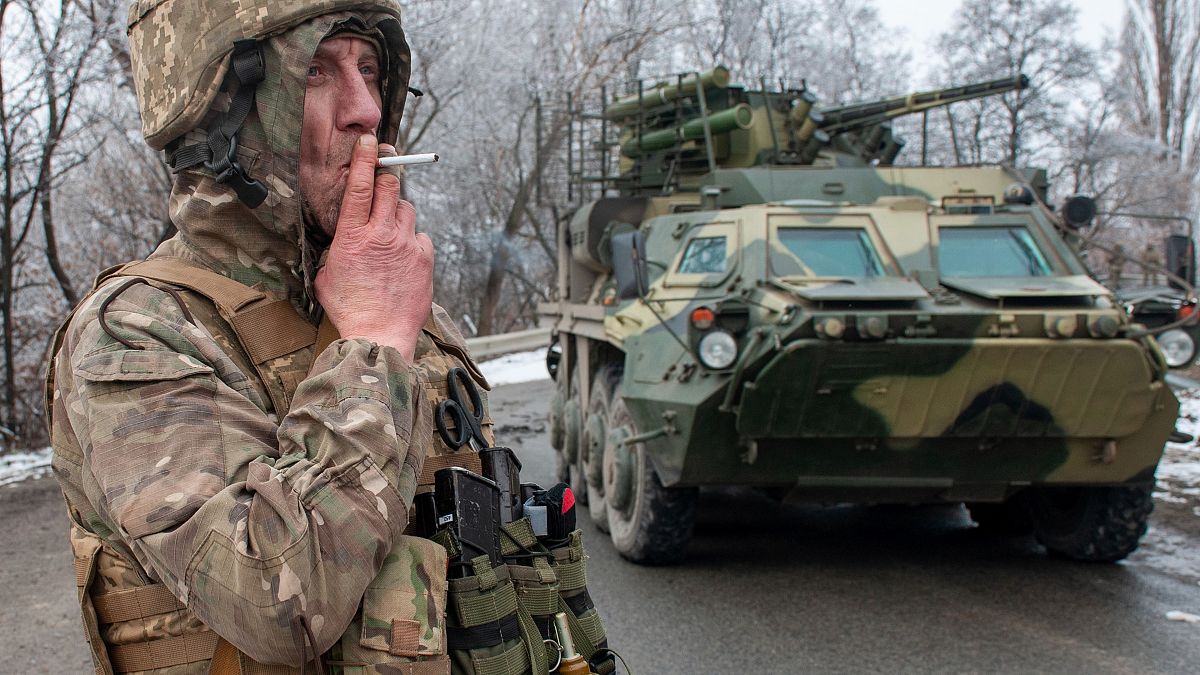  جندي أوكراني يدخن سيجارته في موقعه أمام عربته العسكرية المصفحة في مدينة خاركيف 