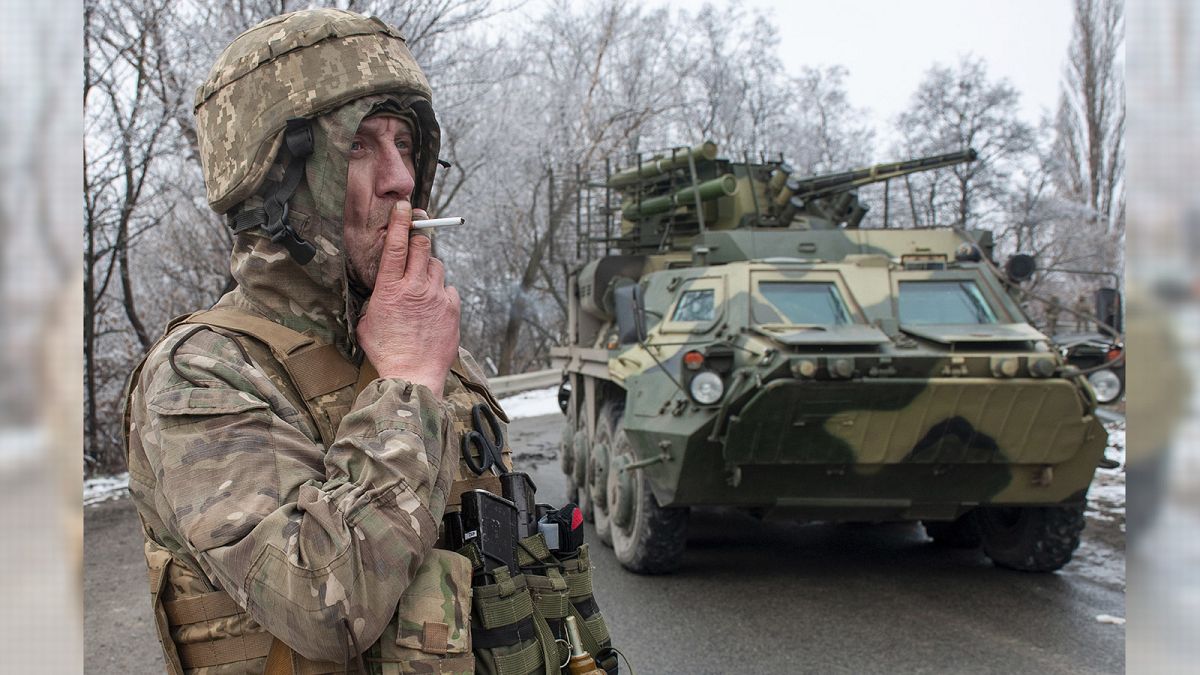 A Ukrainian soldier smokes a cigarette on his position at an armored vehicle outside Kharkiv