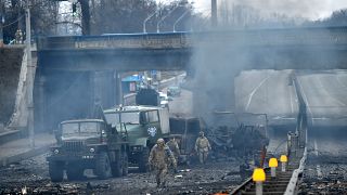 Des membres des services ukrainiens recherchent et ramassent des obus non explosés après un combat avec un groupe de raiders russes dans la capitale ukrainienne de Kyiv.