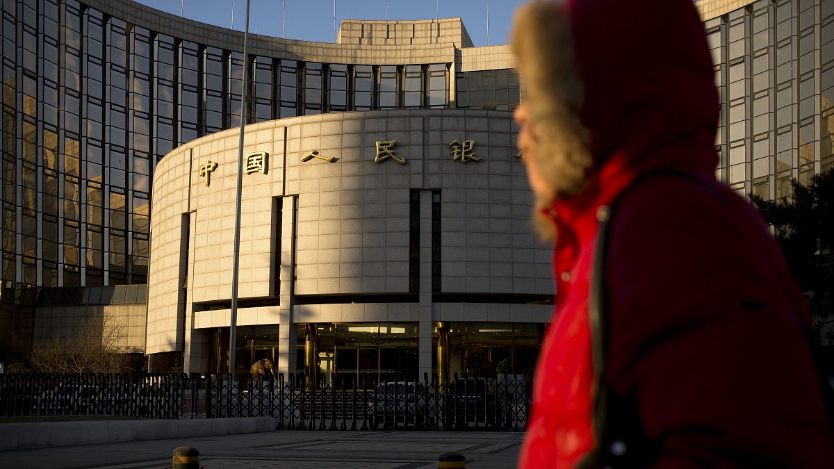 امرأة أمام البنك المركزي الصيني أو بنك الشعب الصيني، في بكين.