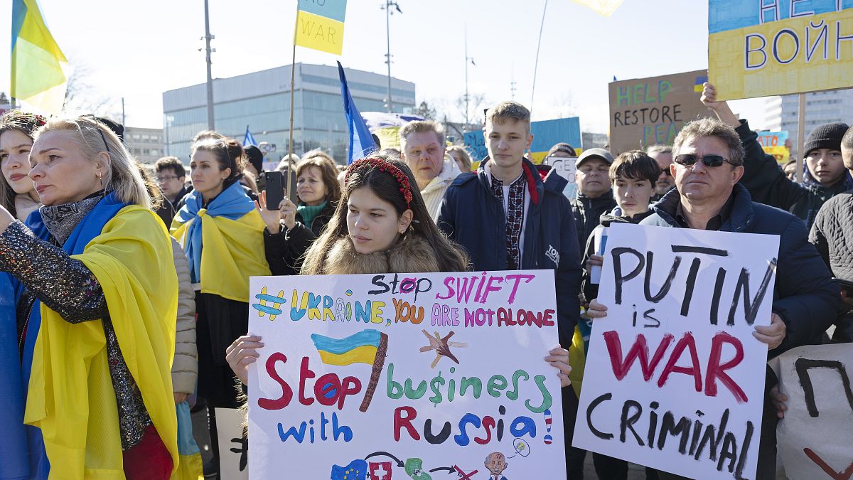Demonstrators hold placards while protesting Russia's military operation against Ukraine during a rally on the place of the United Nations in Geneva, Switzerland, on Saturday