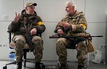 Dois membros das tropas civis ucranianas conversam na câmara municipal de Kiev