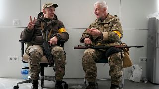 Dois membros das tropas civis ucranianas conversam na câmara municipal de Kiev