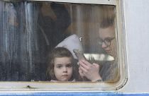 طفلة برفقة والدتها تغادر أوكرانيا في محطة السكك الحديدية في لفيف، غرب أوكرانيا.