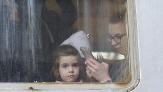 طفلة برفقة والدتها تغادر أوكرانيا في محطة السكك الحديدية في لفيف، غرب أوكرانيا.