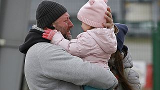 Un père embrasse sa fille après avoir fui le conflit en Ukraine, au poste frontière de Medyka, en Pologne, dimanche 27 février 2022.