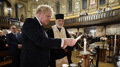 Boris Johnson lights a candle during a visit to the Ukrainian Catholic Eparchy of Holy Family of London, Sunday February 27, 2022, following the Russian invasion of Ukraine.