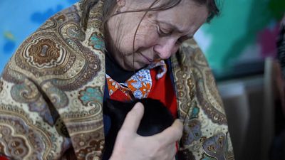 Mariupol resident Alexandra Mikhailova crying and petting cat