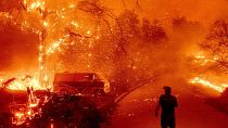 Bruce McDougal watches embers fly over his property as the Bond Fire burns through the Silverado community in Orange County, Calif., on Dec. 3, 2020.