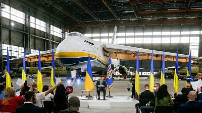 Ukrainian President Volodymyr Zelenskyy gestures while speaking to media with the world's largest airplane, Ukrainian Antonov An-225 Mriya.