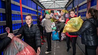 Freiwillige Helfer:innen in Vilnus holen Spenden für ukrainische Flüchtlinge aus dem Laster