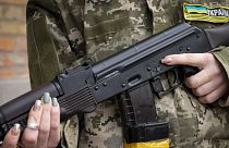 Az ukrán polgári védelem egyik tagja fegyverét tartja járőrözés közben Kijevben