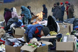 A child collects toys near a clothes donation point as refugees fleeing conflict in Ukraine arrive at the Medyka border crossing in Poland on 28 February 2022.