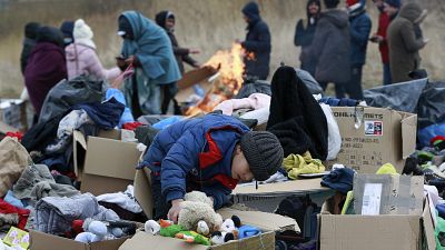 A child collects toys near a clothes donation point as refugees fleeing conflict in Ukraine arrive at the Medyka border crossing in Poland on 28 February 2022.