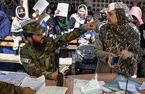 یک زن مسن افغان در اداره گذرنامه در حال صحبت با مامور طالبان، اکتبر ۲۰۲۱