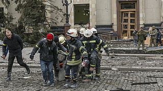Personal de los servicios de emergencia ucranianos sacan el cuerpo de una víctima del edificio dañado del Ayuntamiento tras un bombardeo en Jarjóv, Ucrania, el martes