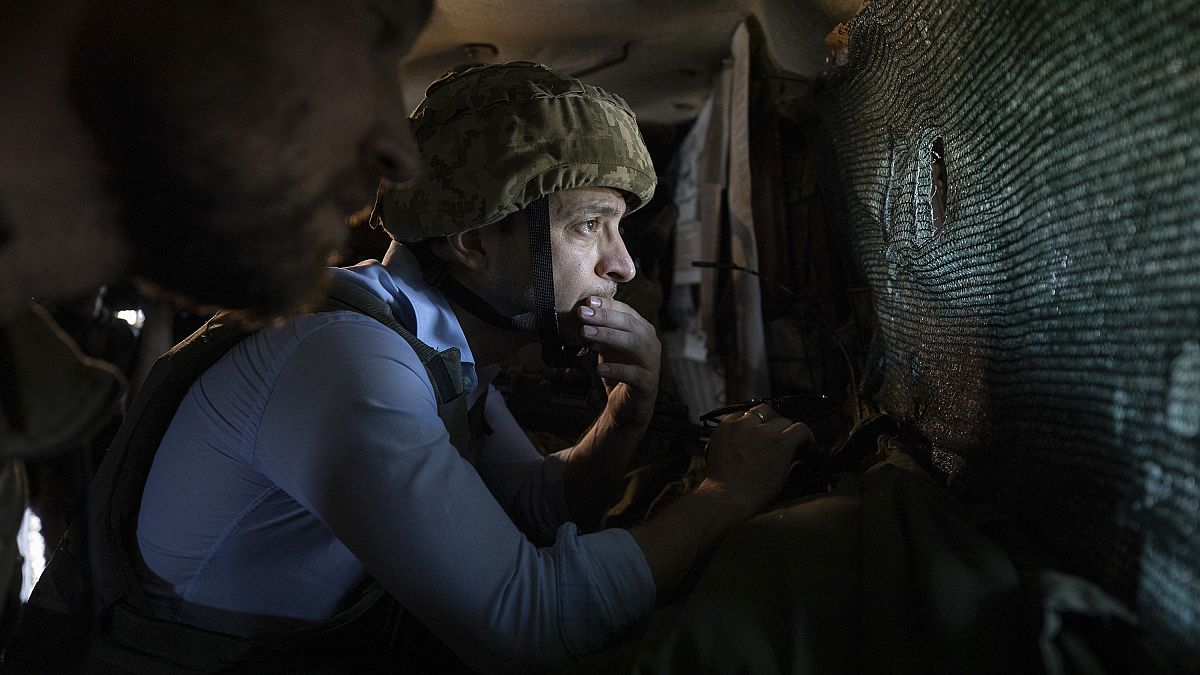 El presidente Volodímir Zelenski observa una posición de primera línea desde un refugio mientras visita el este de Ucrania