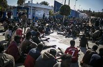 ARCHIVO - Migrantes descansan en un centro de retención tras cruzar las vallas que separan el enclave español de Melilla de Marruecos, en Melilla, España, 2/3/2022