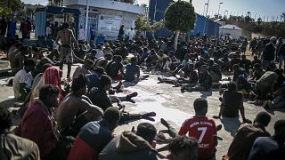 ARCHIVO - Migrantes descansan en un centro de retención tras cruzar las vallas que separan el enclave español de Melilla de Marruecos, en Melilla, España, 2/3/2022