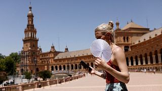 A woman fans herself during the first heatwave of the year in Seville, June 11.