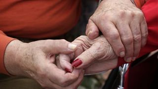 In this 2013 photo, Holocaust survivor Joe Chaba holds hands with his wife, Helen Chaba, at their home in Chicago.