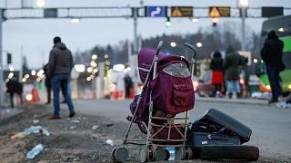 Deserted suitcase and a baby cart are left beside the road as Ukrainian refugees flee Russian invasion at a border crossing in Medyka, Poland, on March 2, 2022.
