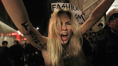 A topless Ukrainian activist of the group "Femen" shouts as she stages a protest at the entrance of the Versace Women's Fall-Winter 2012-13 in Milan