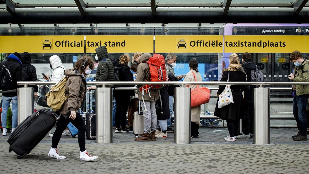 Passengers wait for taxis at the official taxi rank of Schiphol Airport, in Schiphol