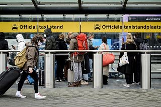 Passengers wait for taxis at the official taxi rank of Schiphol Airport, in Schiphol